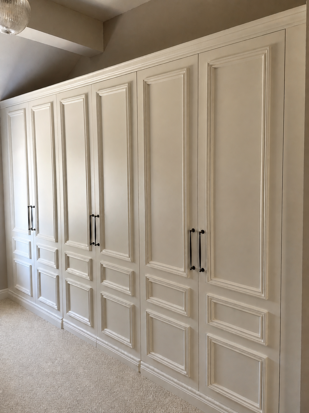 Cream bespoke panelled wardrobes with black handles