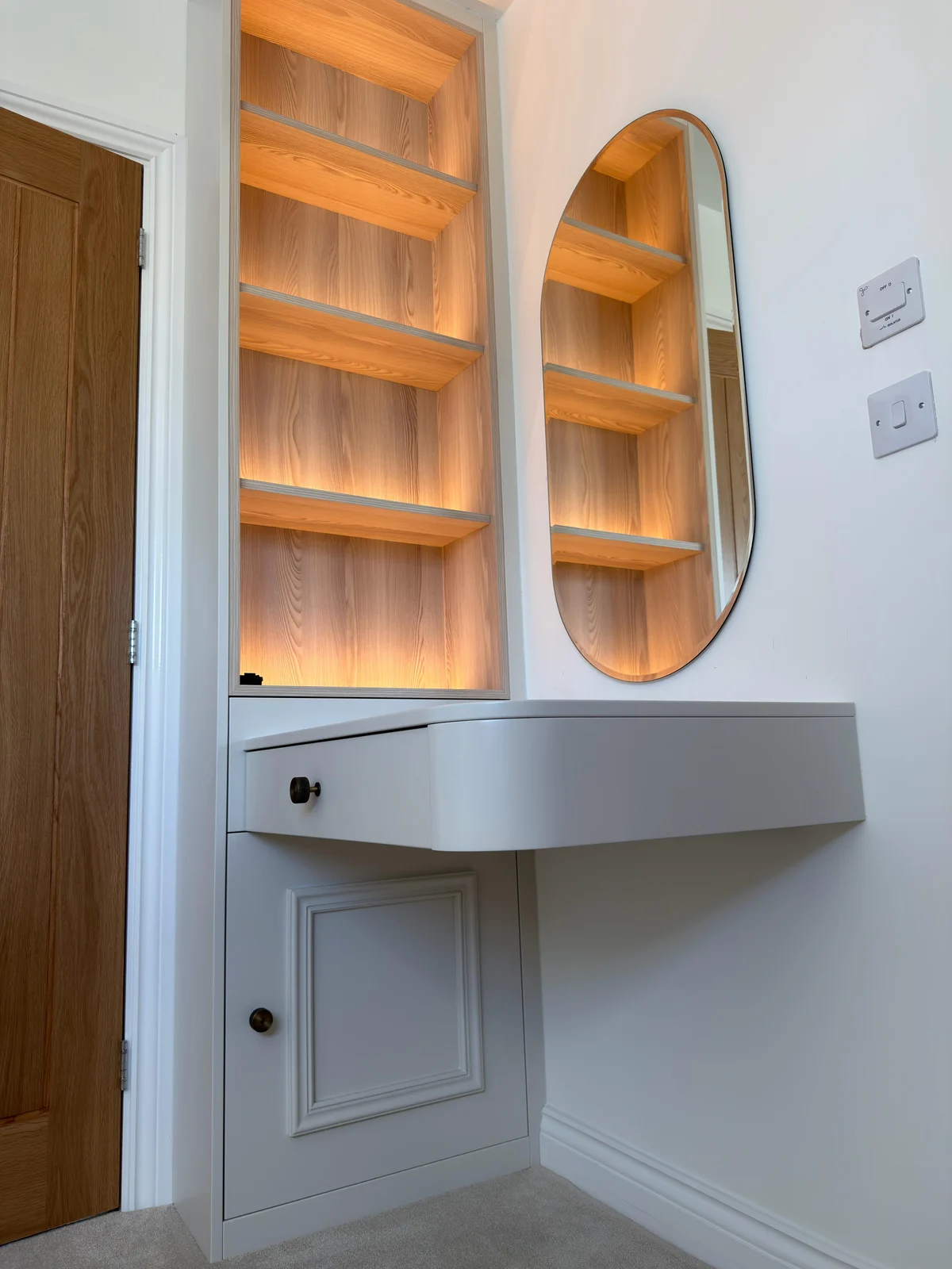 Fitted dressing table with illuminated oak shelving and an oval mirror